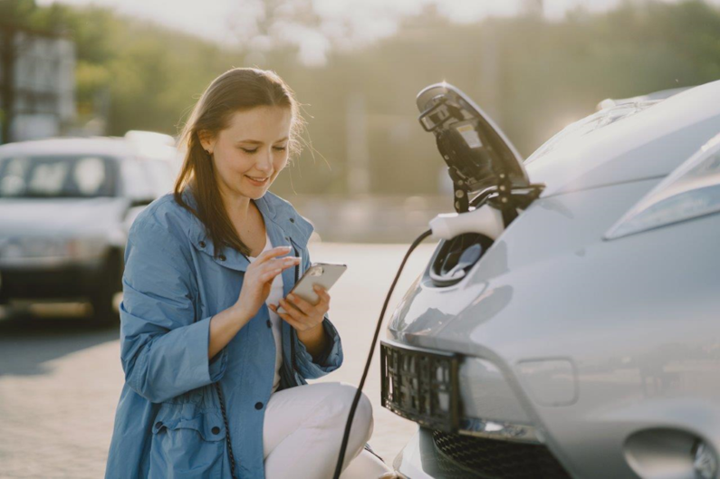 image of woman charging her ev at ev charge station