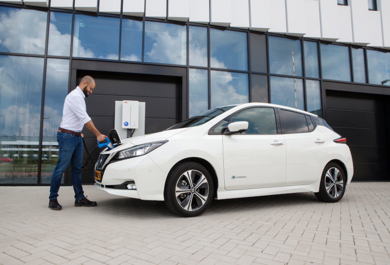 image of man plugging in his electric vehicle to a charging point